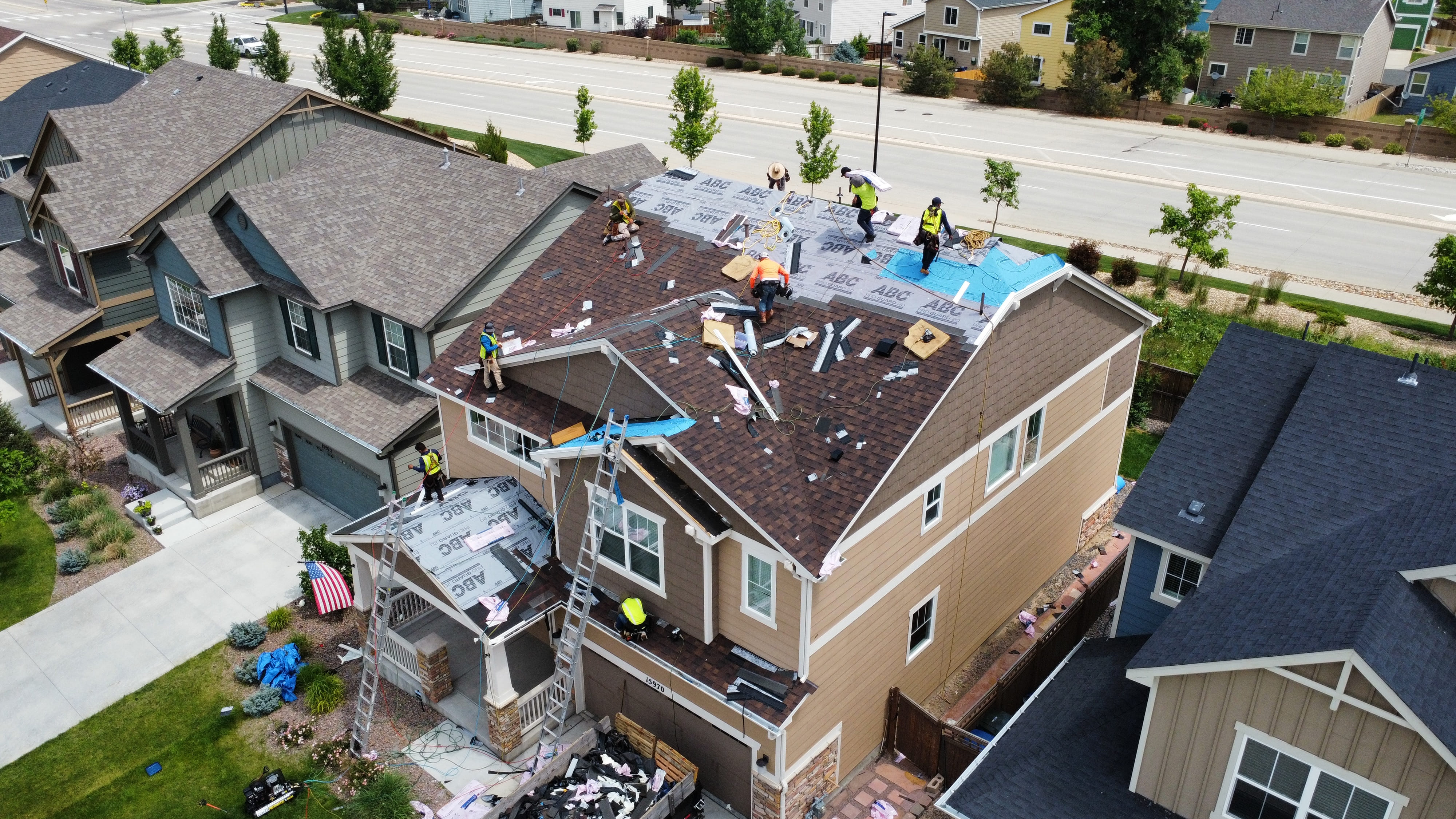 Large residential property with several roof sections being replaced