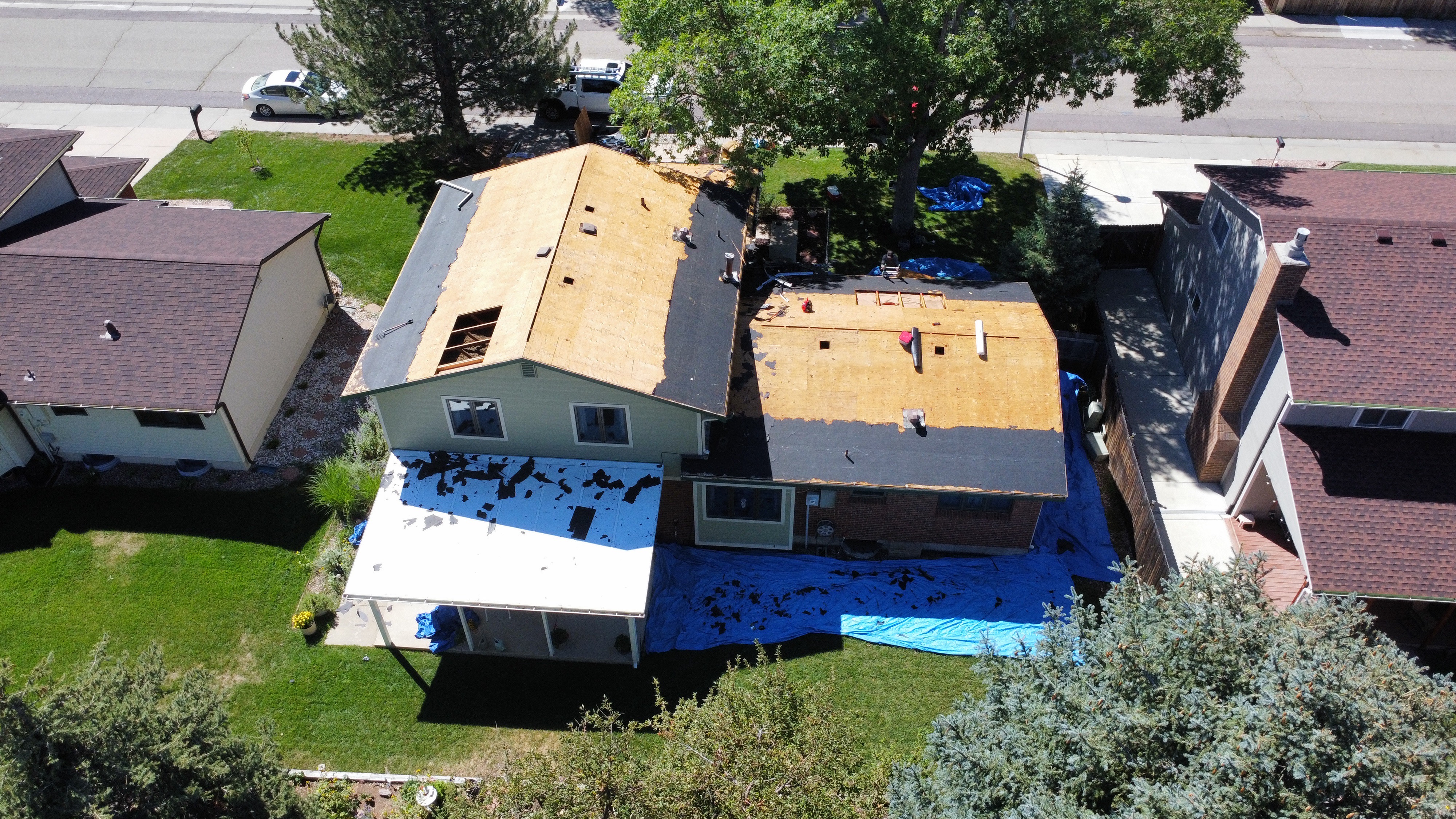 Aerial view of a house with roof decking exposed during replacement